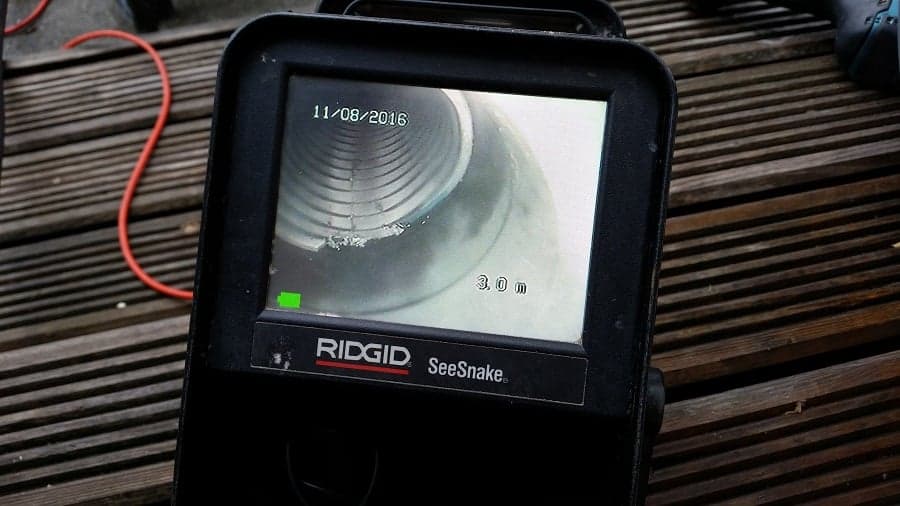 Loodgieter voert camera-inspectie uit in rioolleiding